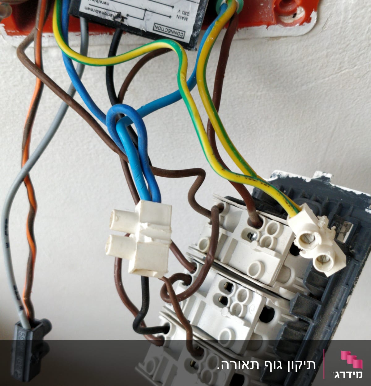 חוטי חשמל מחוברים למתג בקיר פתוח